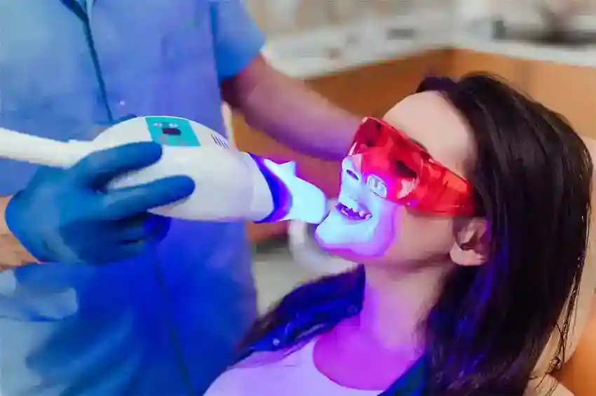 Smiling female patient undergoing Zoom Laser Teeth Whitening with dental specialist Watford